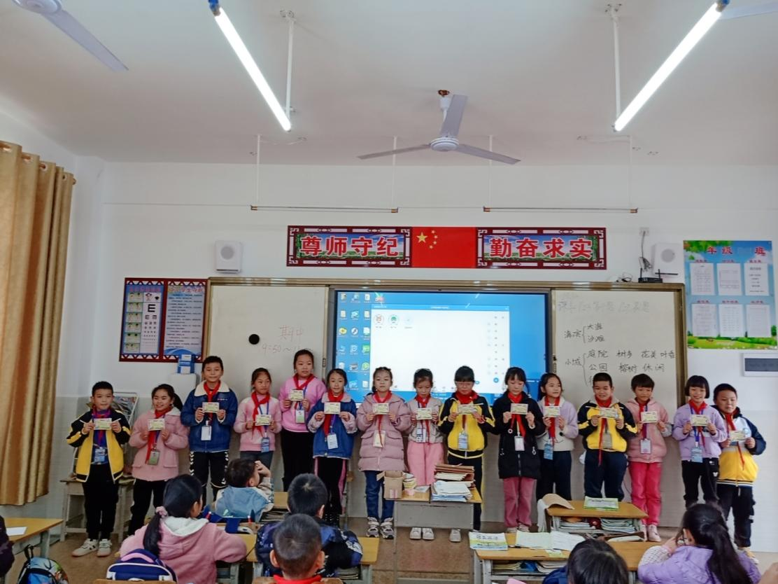 实习生给班上的学生颁发成绩优秀奖